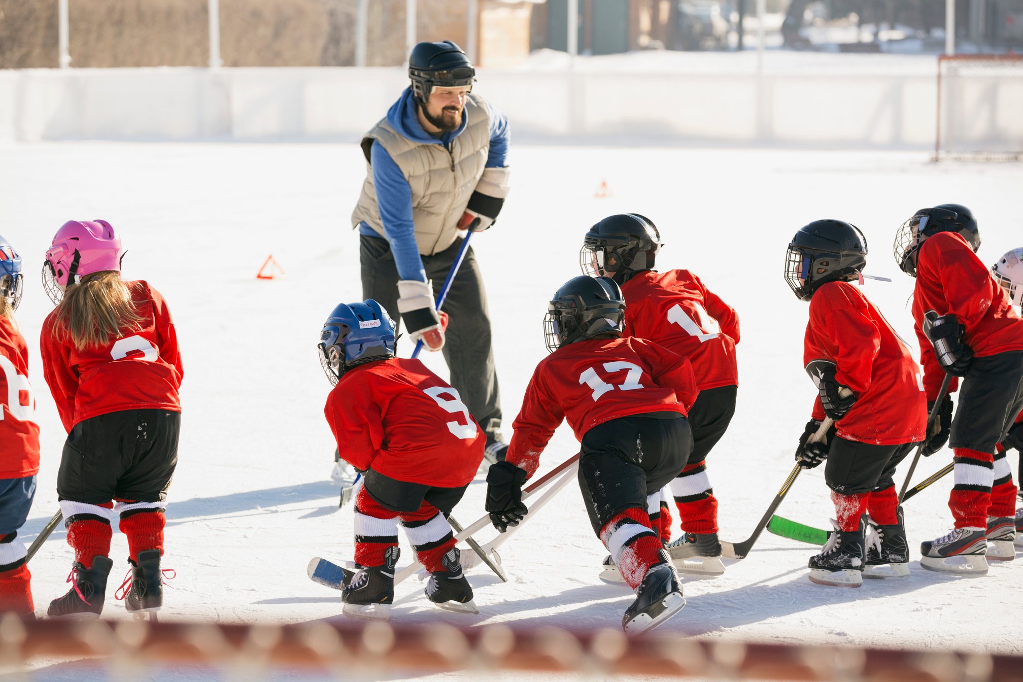 Coach instructing ice hockey team on rink